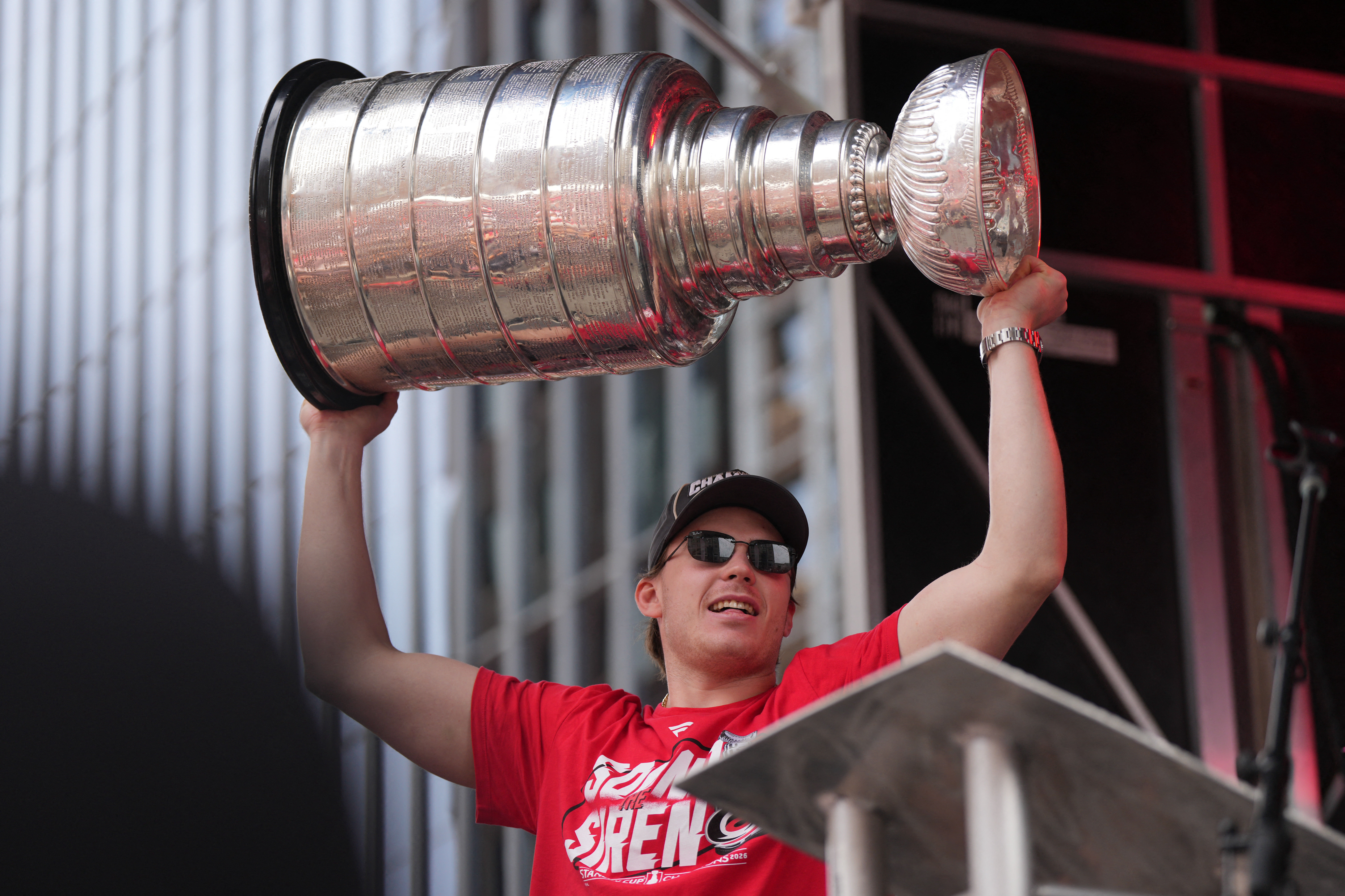 Carolina Hurricanes defenseman Alexander Nikishin (21) holds up the Stanley Cup Trophy during the Stanley Cup championship parade and rally at Raleigh.